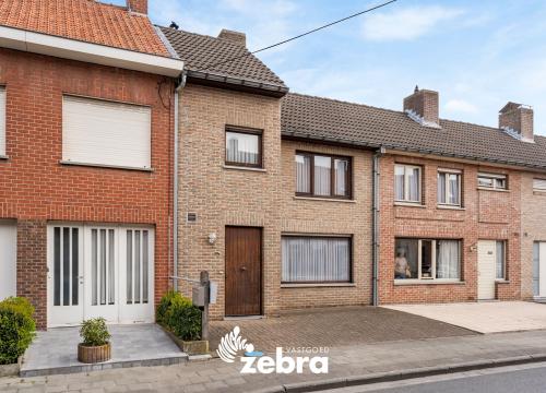 Licht op te frissen woning met drie slaapkamers, garage en uitweg te Rumbeke!